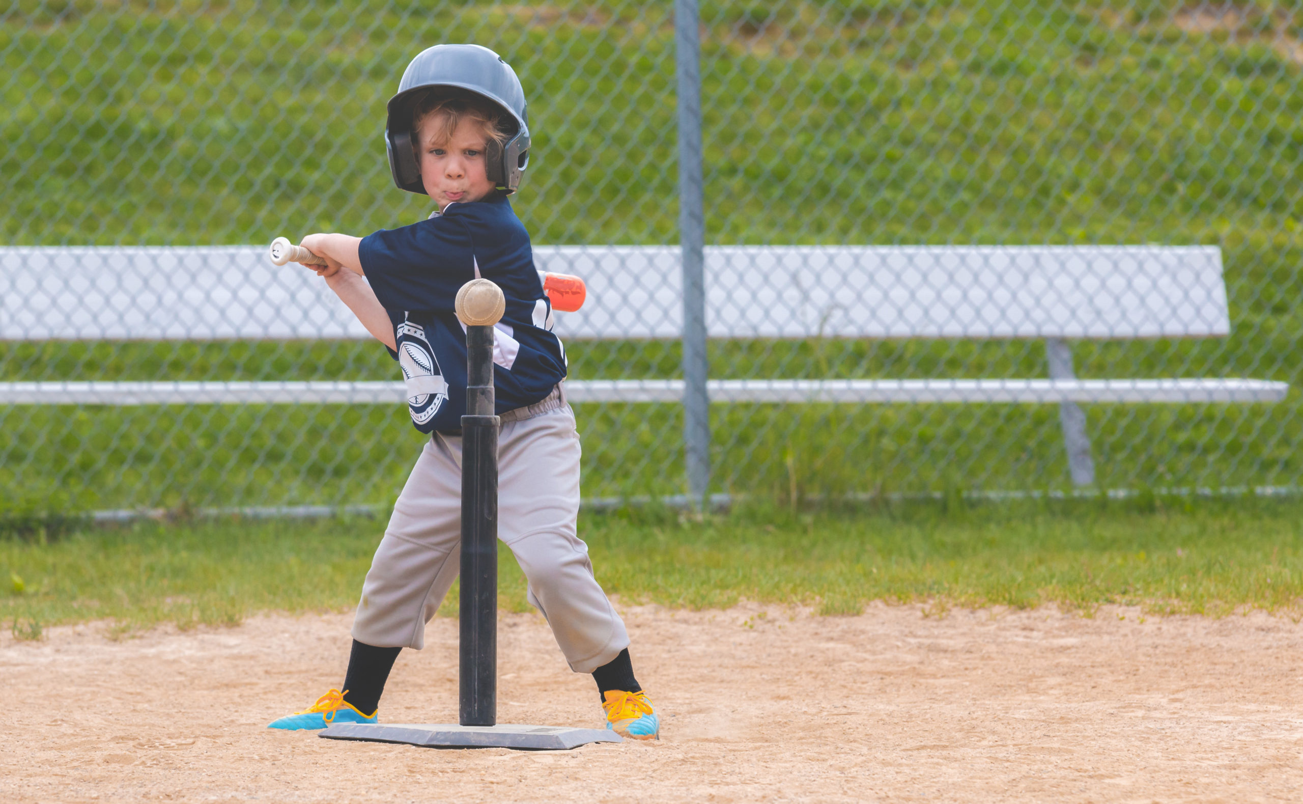 Young Child Playing Baseball Kid hitting ball on t ball stand