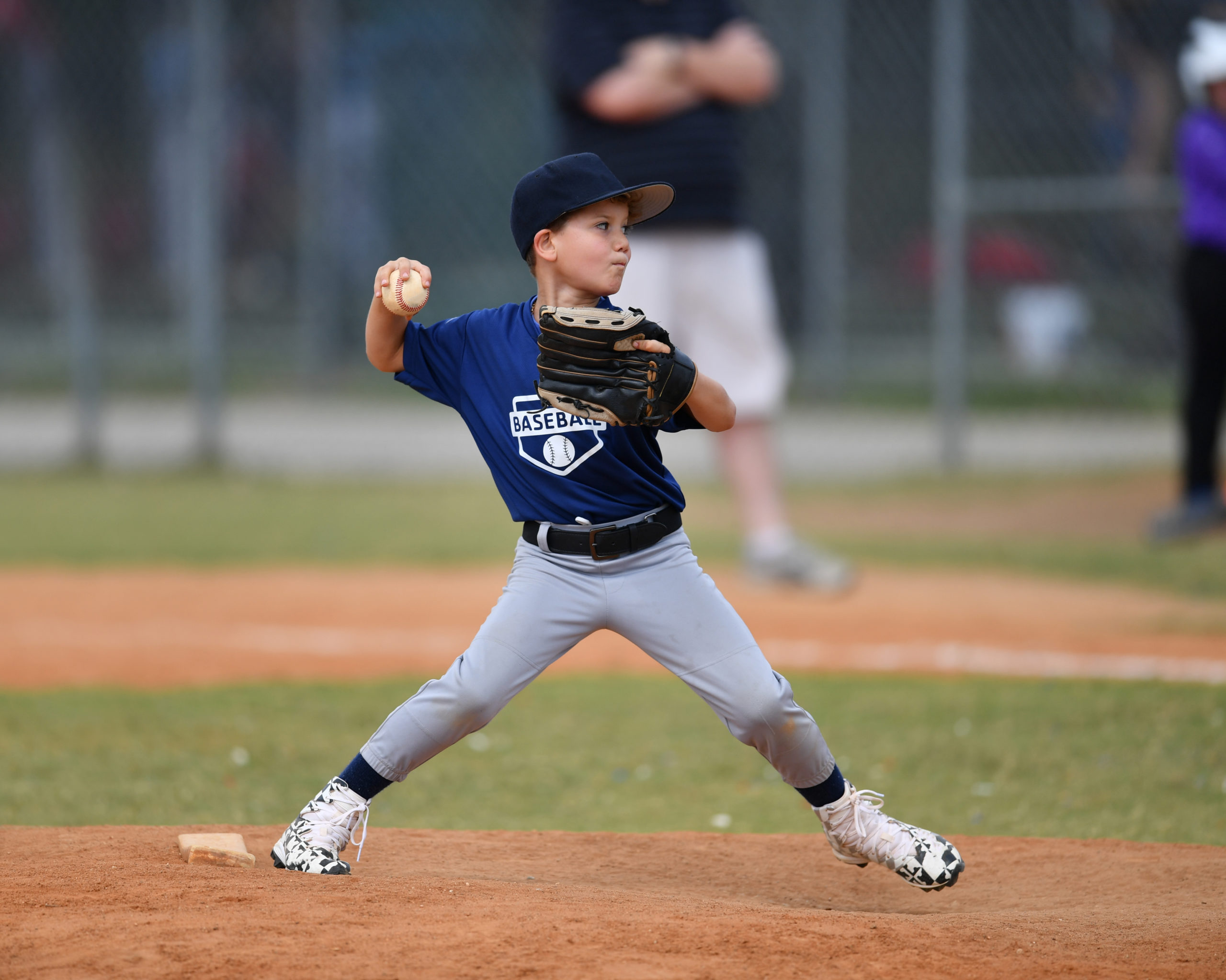 Young baseball pitcher in wind up about to through the ball